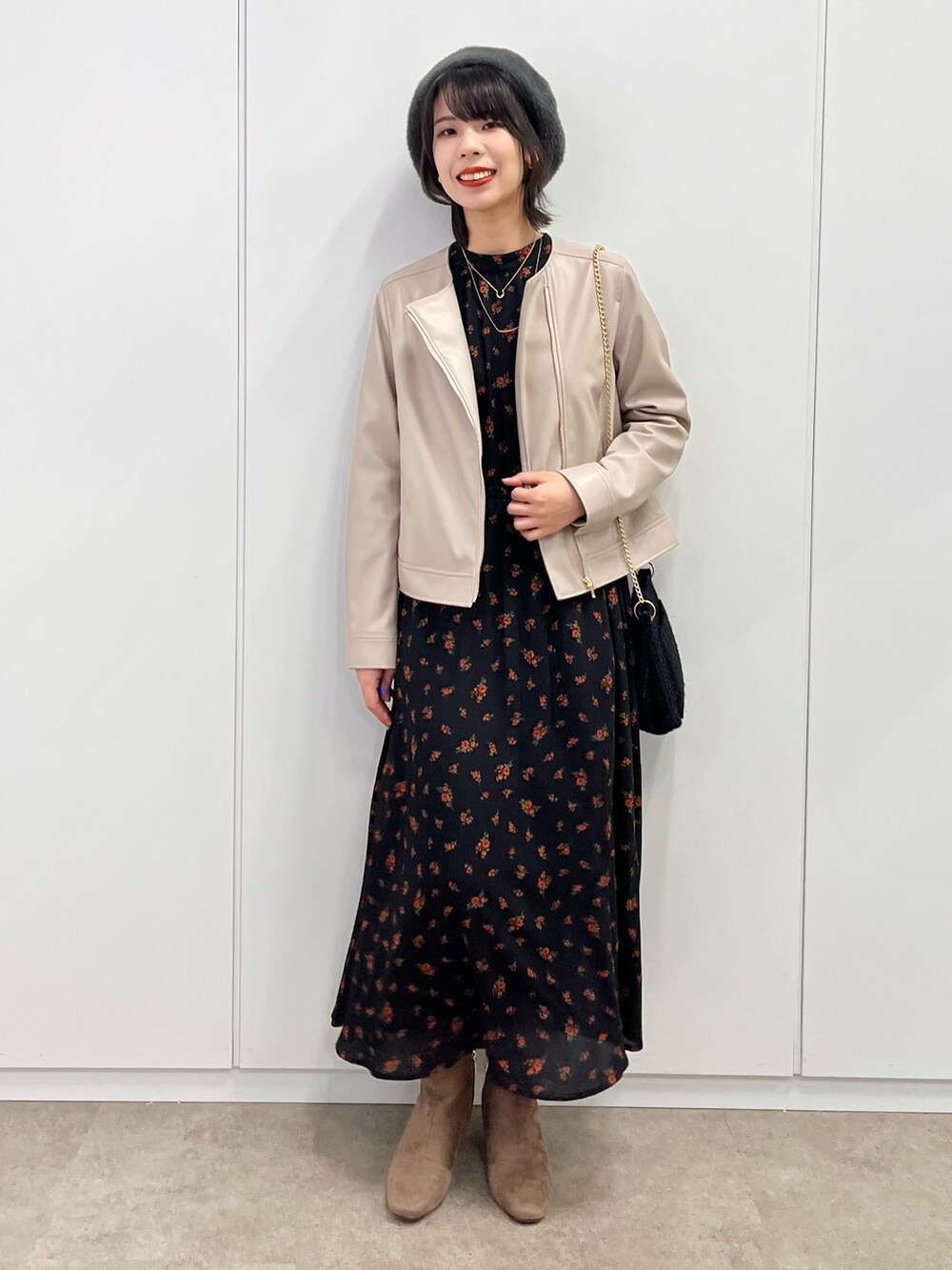 グレー系のブーツ、ブラック系のワンピース、ベージュ系のライダースジャケットを着用したレディースの秋コーディネートの2枚目の写真