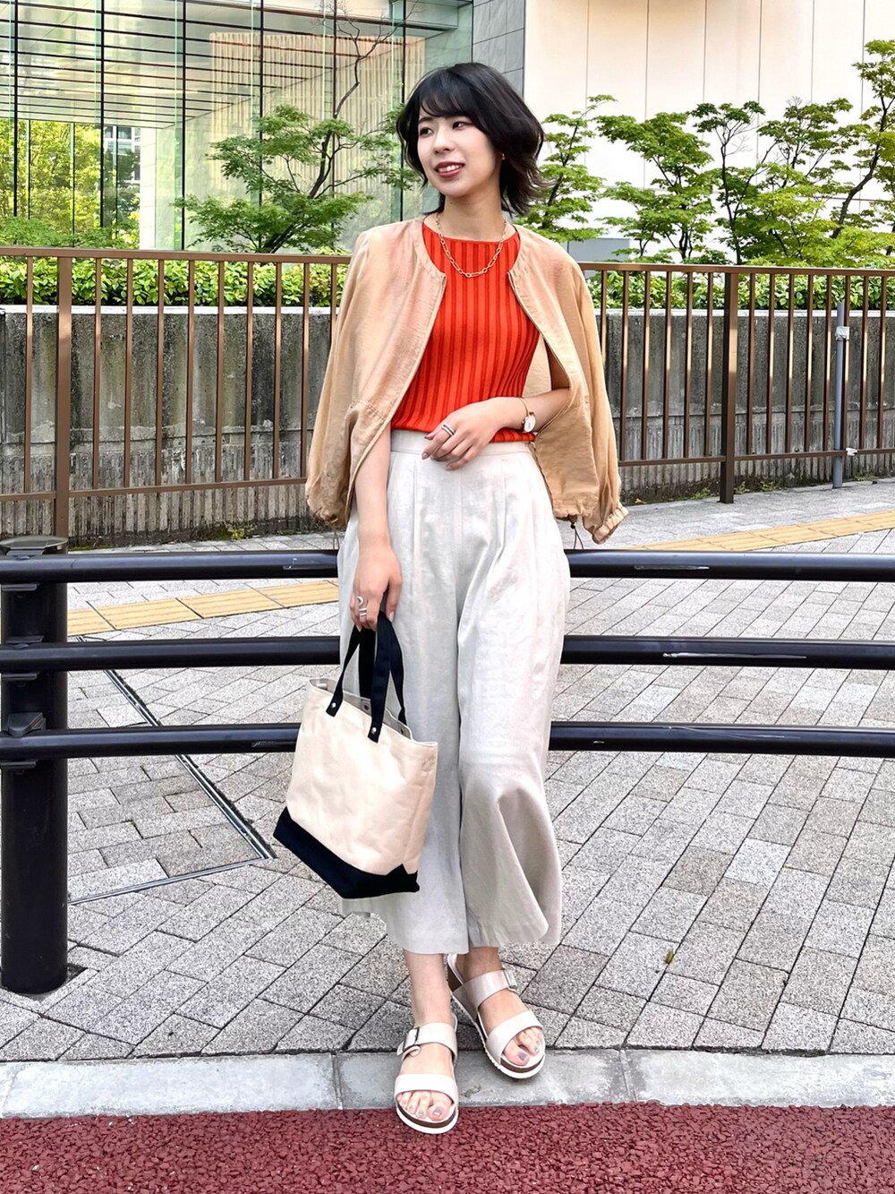 ホワイト系のサンダル、レッド系のニット/セーター、イエロー系のブルゾンを着用したレディースの夏コーディネートの2枚目の写真