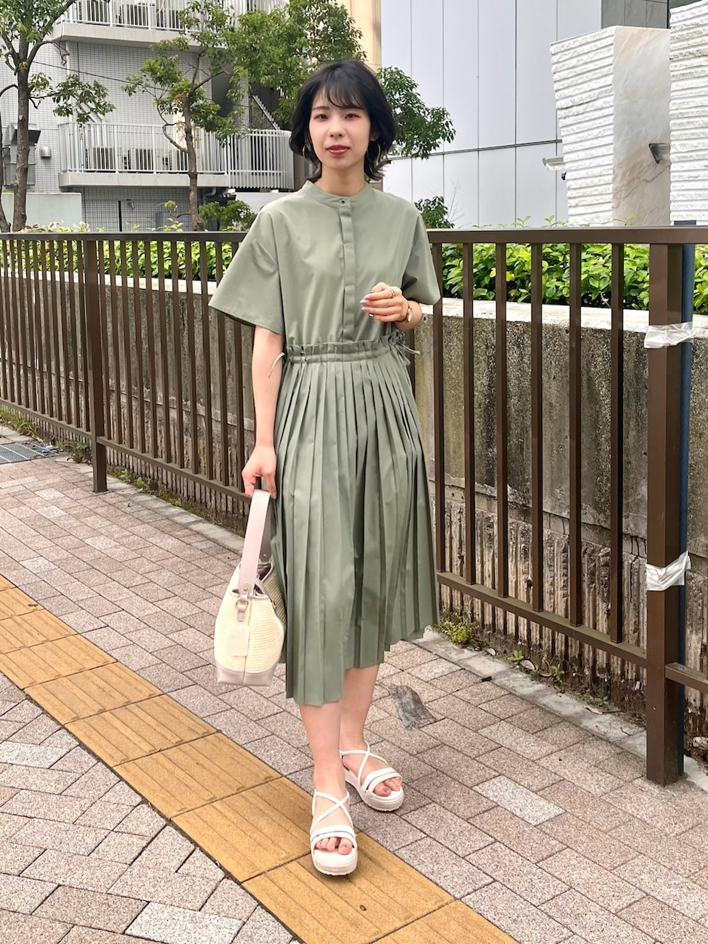 グリーン系のワンピース、グレー系のショルダーバッグ、ホワイト系のサンダルを着用したレディースの夏コーディネートの3枚目の写真