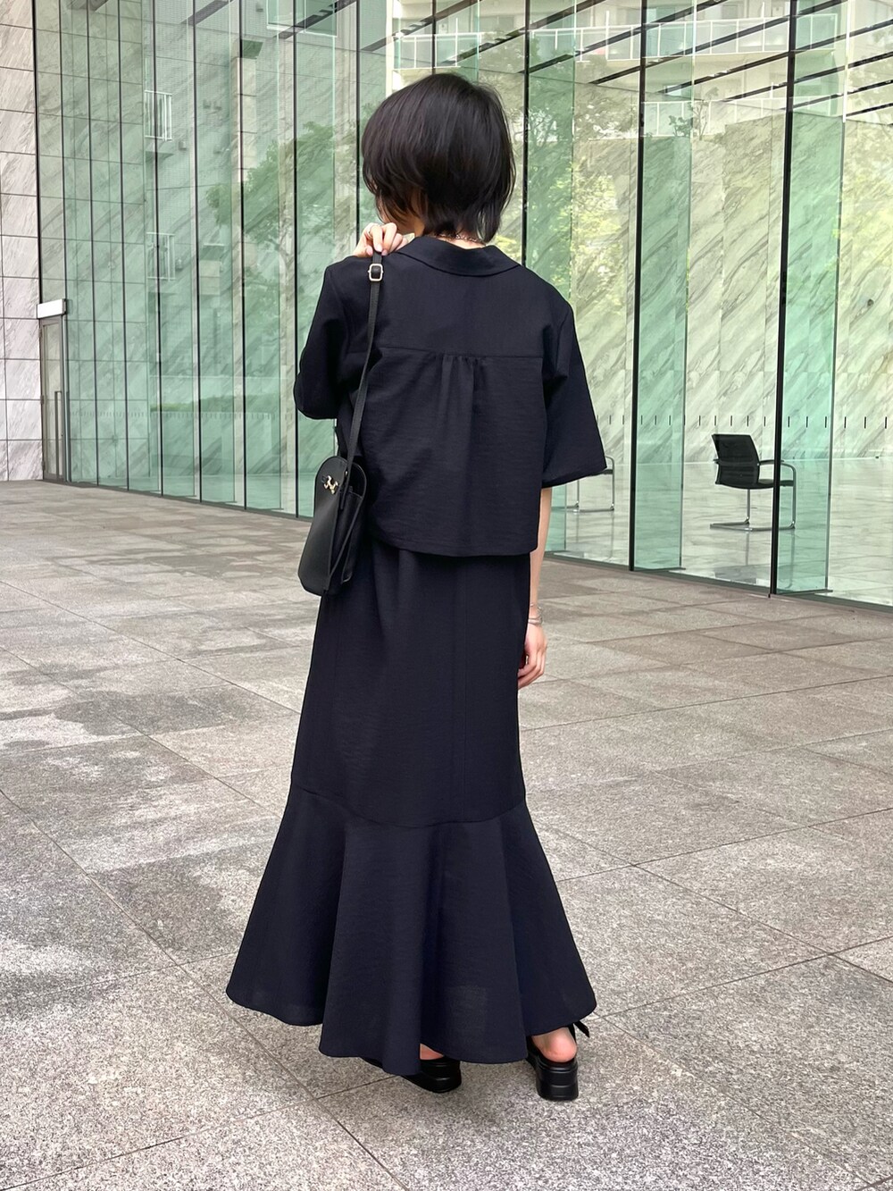 ブラック系のアンサンブル、ベージュ系のタンクトップ、ブラック系のサンダルを着用したレディースの夏コーディネートの2枚目の写真