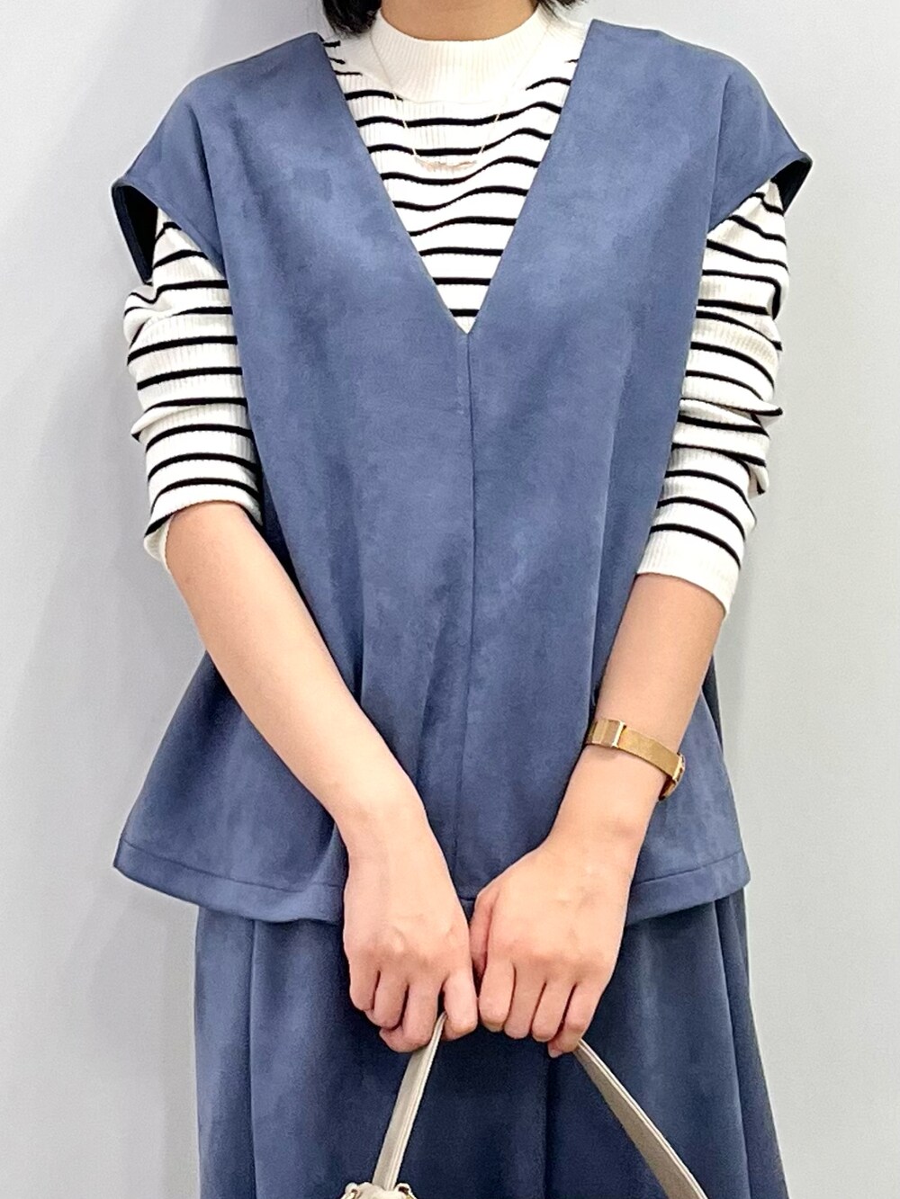 ホワイト系のブーツ、ブルー系のセットアップ、ホワイト系のニット/セーターを着用したレディースの秋コーディネートの4枚目の写真