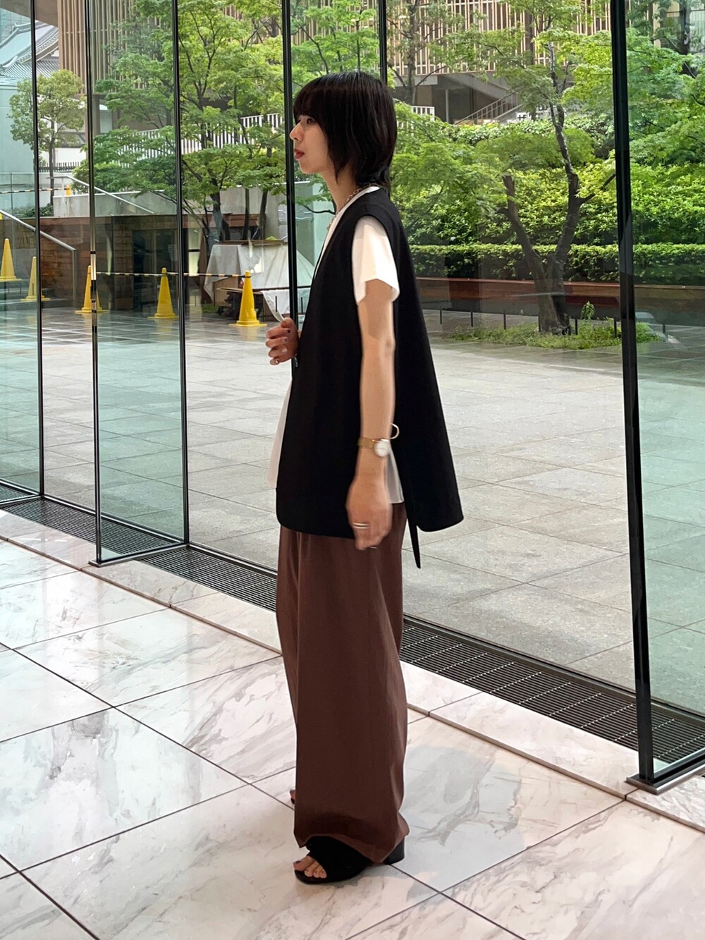 ブラウン系のその他パンツ、ブラック系のサンダル、ホワイト系のTシャツ/カットソーを着用したレディースの夏コーディネートの3枚目の写真