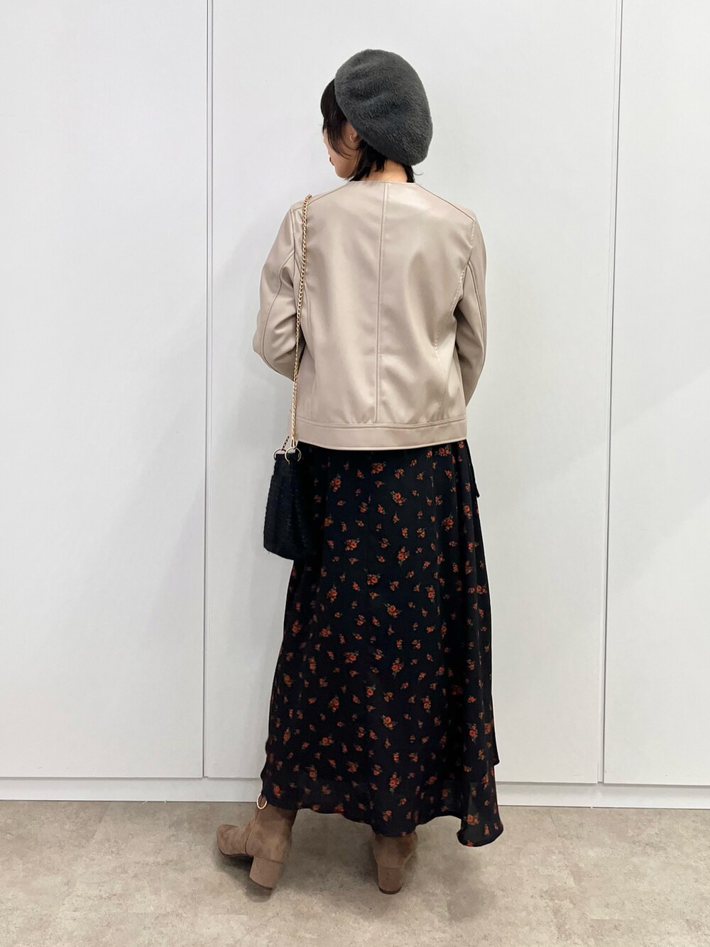 グレー系のブーツ、ブラック系のワンピース、ベージュ系のライダースジャケットを着用したレディースの秋コーディネートの4枚目の写真