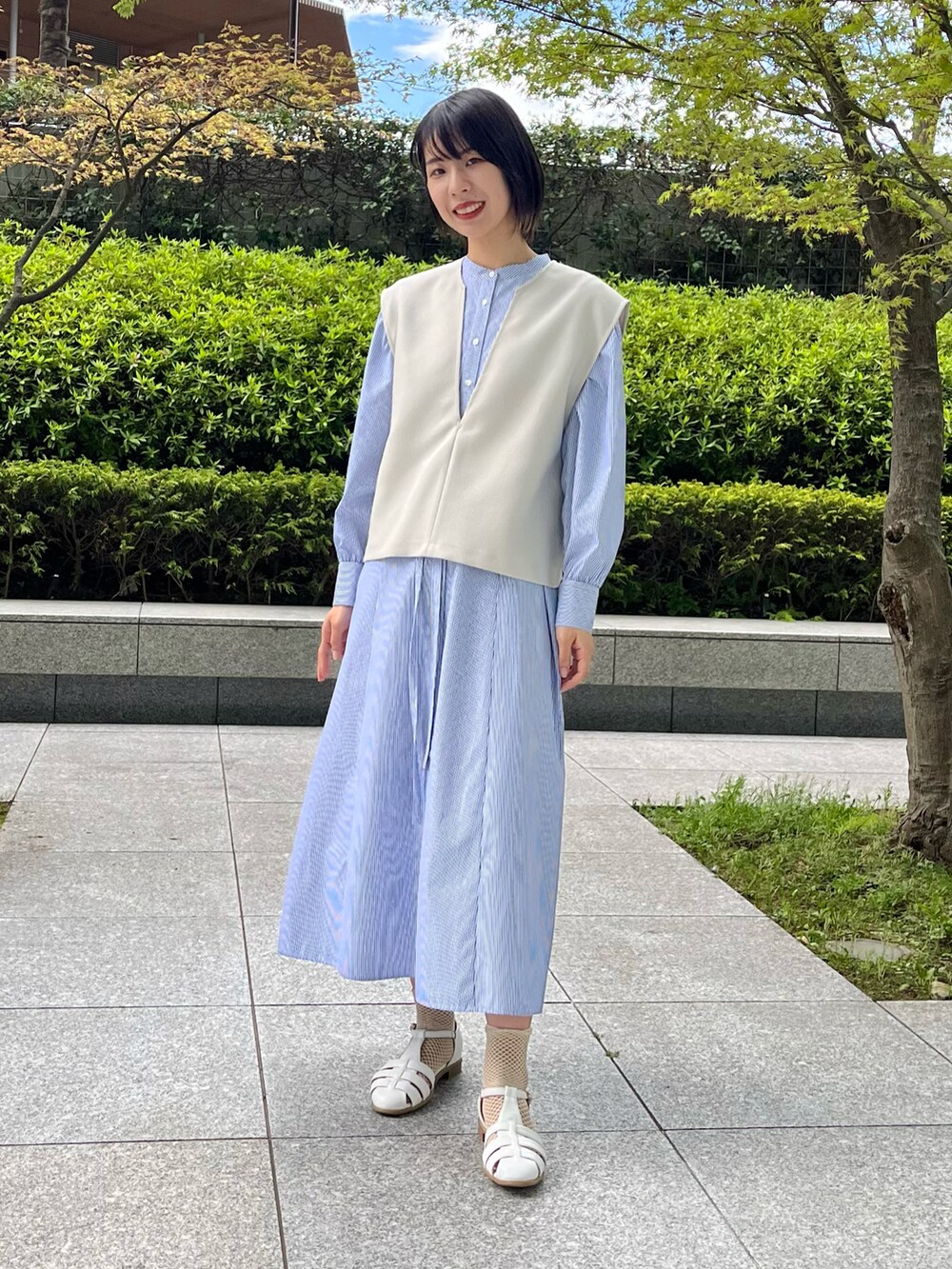 ホワイト系のサンダル、ブルー系のワンピース、ベージュ系のセットアップを着用したレディースの夏コーディネートの2枚目の写真