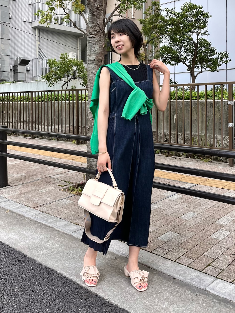 ホワイト系のショルダーバッグ、ホワイト系のサンダル、グリーン系のカーディガン/ボレロを着用したレディースの夏コーディネートの2枚目の写真