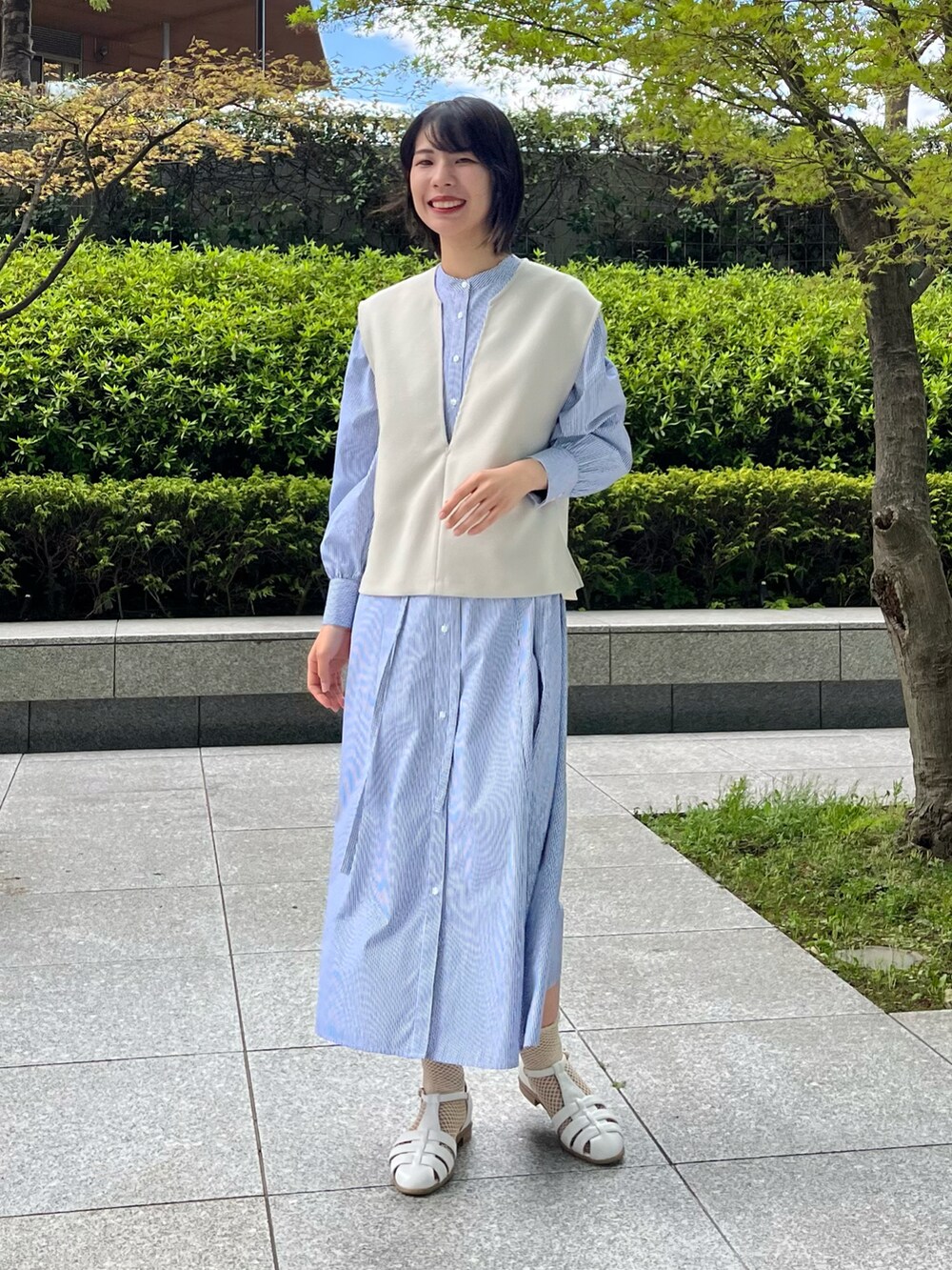 ホワイト系のサンダル、ブルー系のワンピース、ベージュ系のセットアップを着用したレディースの夏コーディネートの4枚目の写真