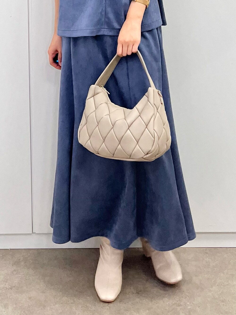 ホワイト系のブーツ、ブルー系のセットアップ、ホワイト系のニット/セーターを着用したレディースの秋コーディネートの5枚目の写真