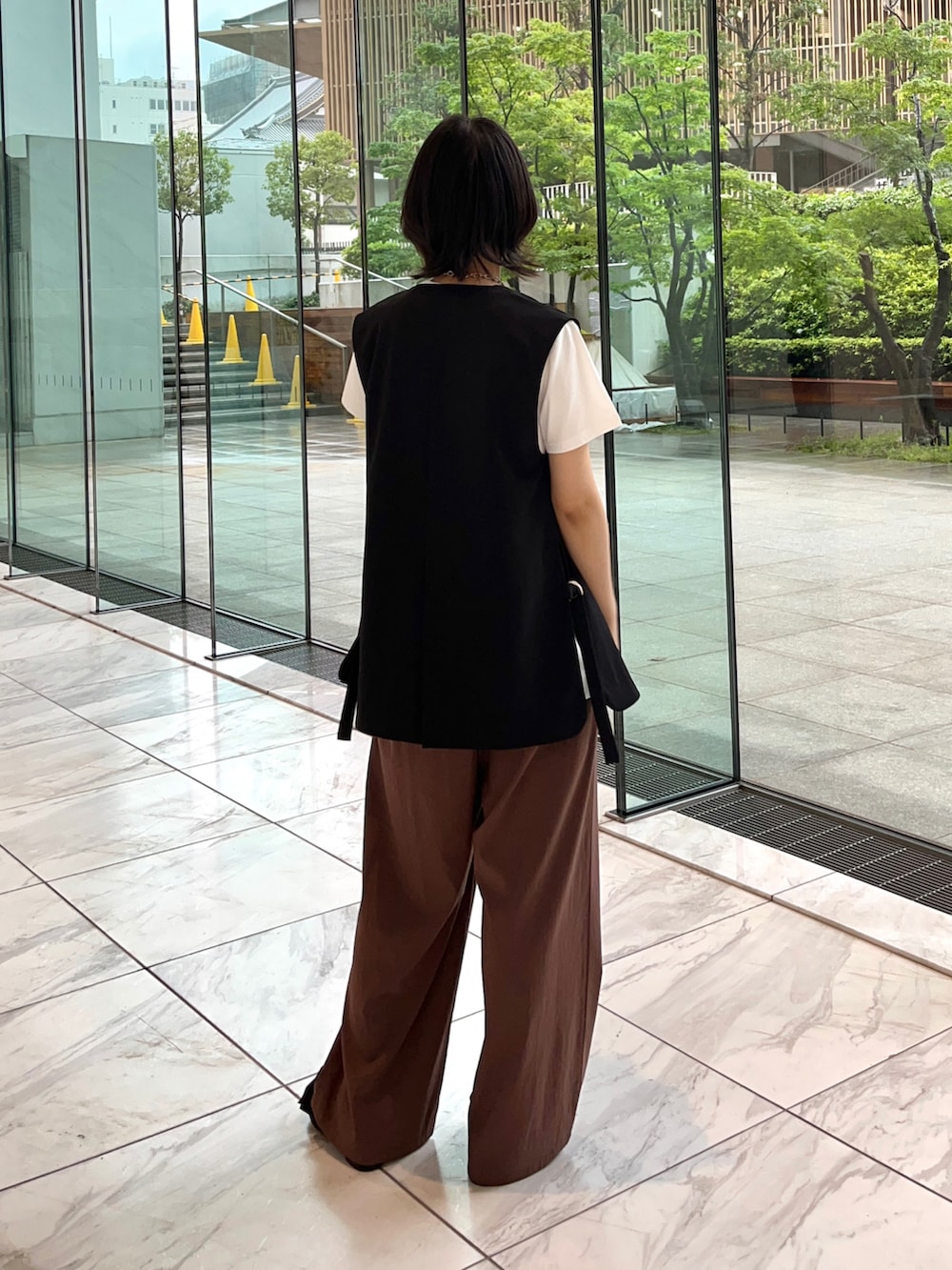 ブラウン系のその他パンツ、ブラック系のサンダル、ホワイト系のTシャツ/カットソーを着用したレディースの夏コーディネートの4枚目の写真