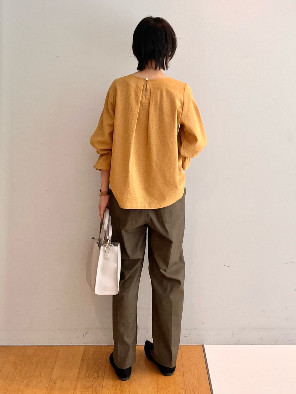 ブラック系のパンプス、グレー系のトートバッグ、グリーン系のその他パンツを着用したレディースの秋コーディネートの4枚目の写真