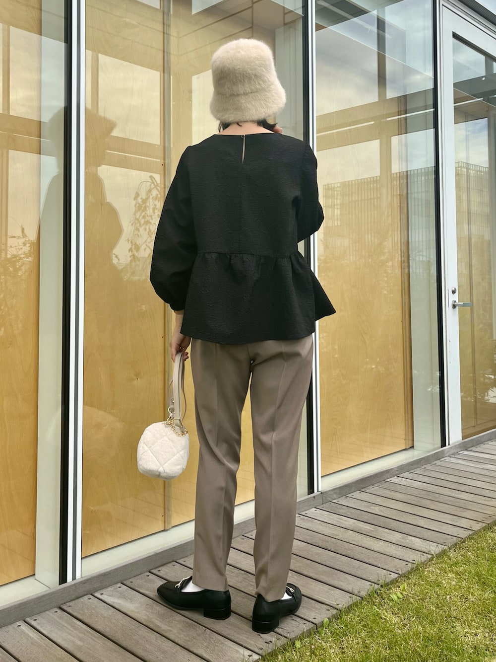 ブラウン系のその他パンツ、ブラック系のその他シューズ、ホワイト系のショルダーバッグを着用したレディースの秋コーディネートの2枚目の写真