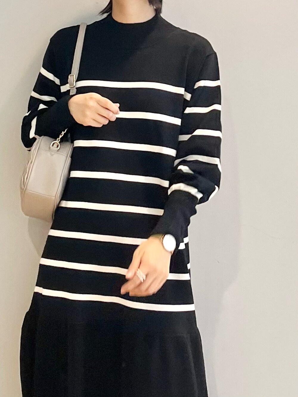 グレー系のブーツ、ホワイト系のワンピース、グレー系のショルダーバッグを着用したレディースの秋コーディネートの5枚目の写真