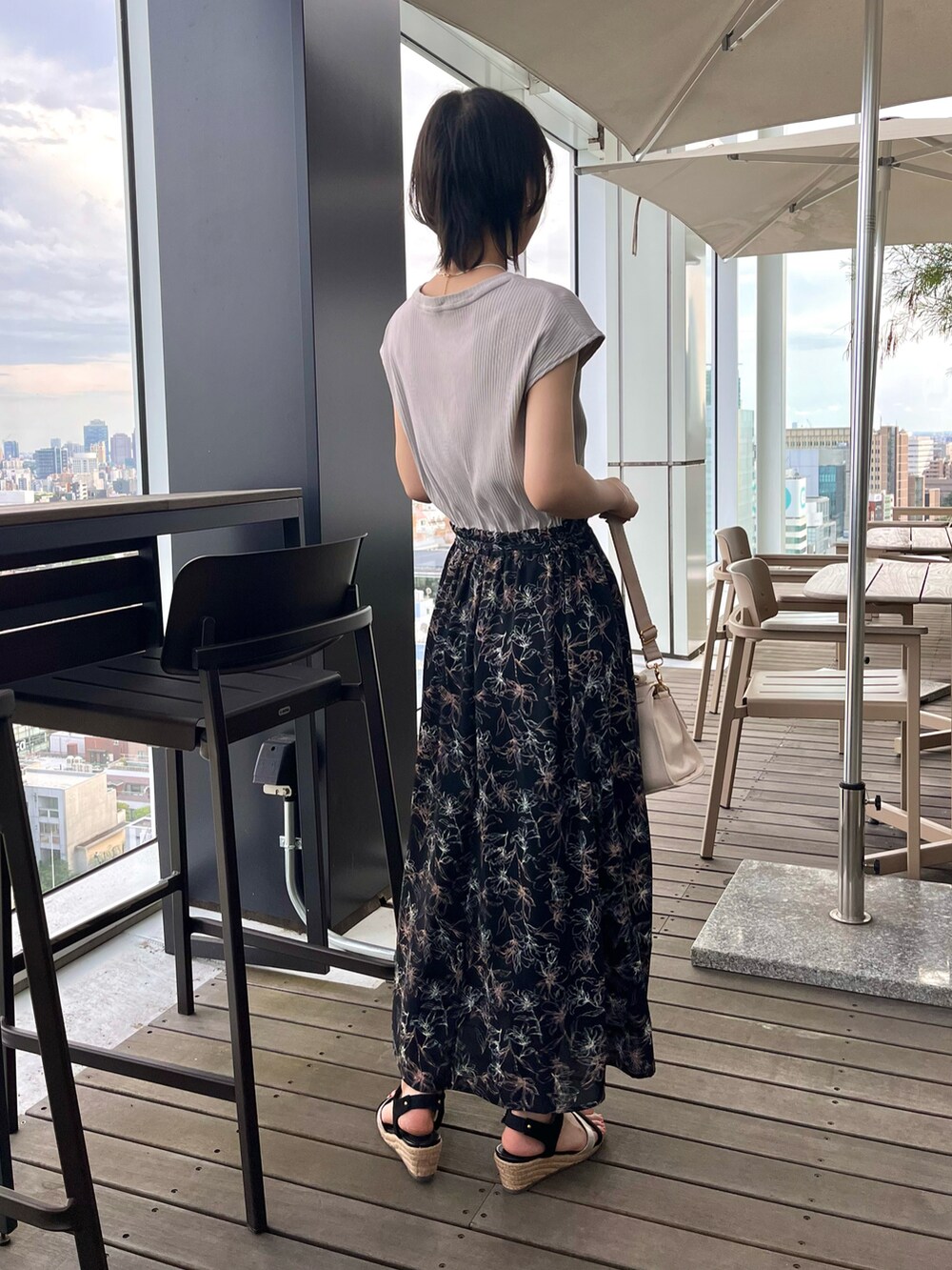 ブラック系のサンダル、ブラック系のワンピース、ホワイト系のショルダーバッグを着用したレディースの夏コーディネートの5枚目の写真