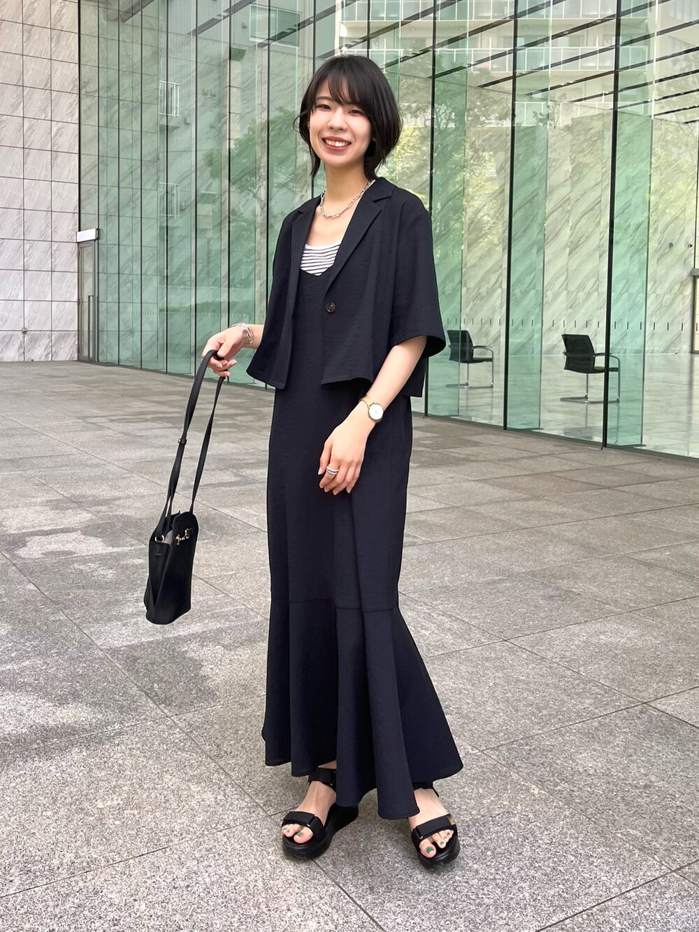 ブラック系のアンサンブル、ベージュ系のタンクトップ、ブラック系のサンダルを着用したレディースの夏コーディネートの3枚目の写真