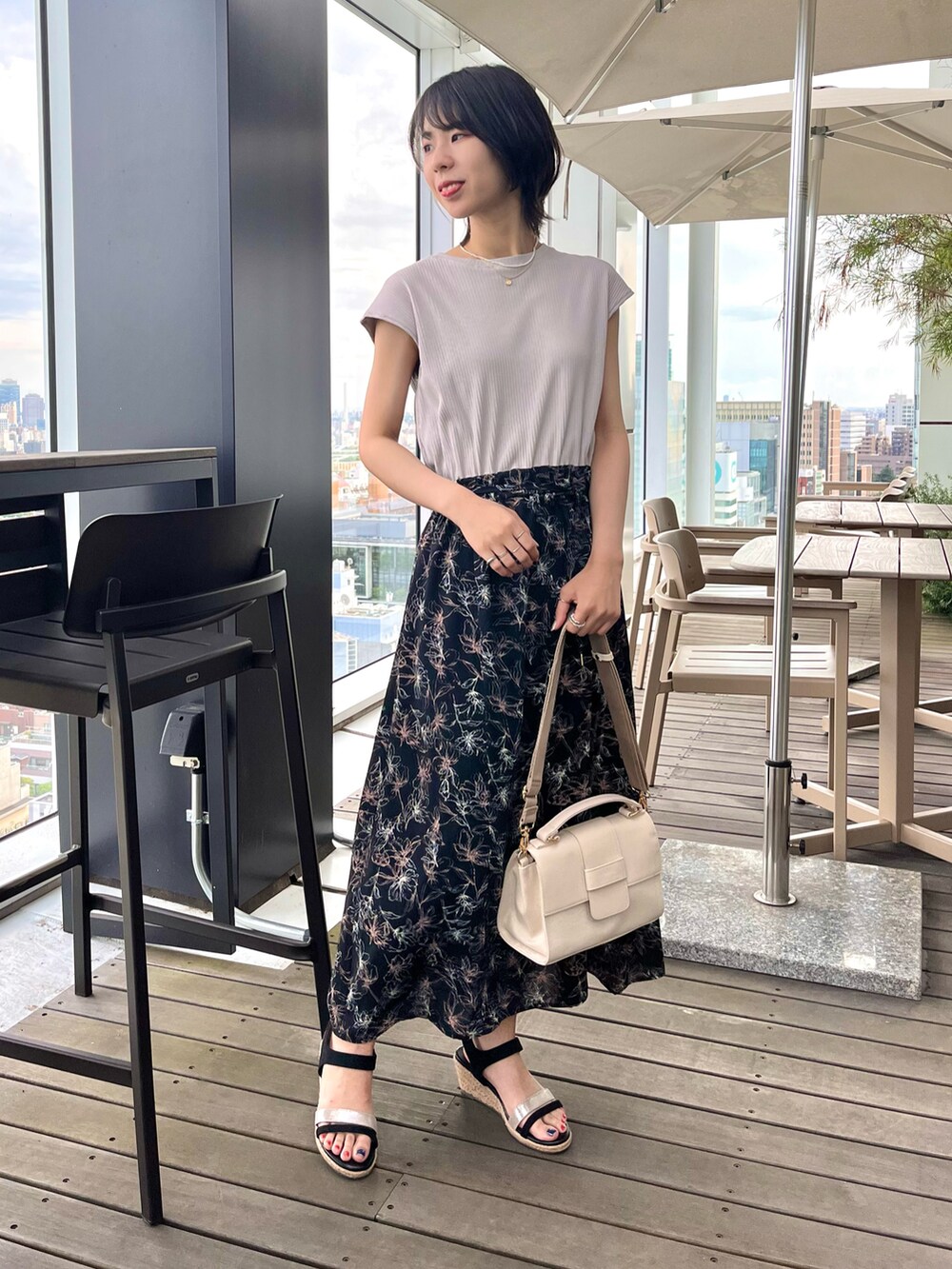 ブラック系のサンダル、ブラック系のワンピース、ホワイト系のショルダーバッグを着用したレディースの夏コーディネートの2枚目の写真