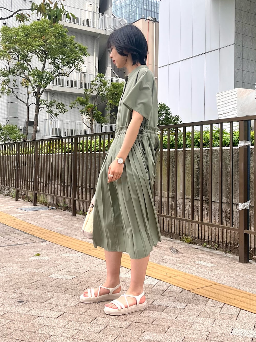 グリーン系のワンピース、グレー系のショルダーバッグ、ホワイト系のサンダルを着用したレディースの夏コーディネートの2枚目の写真