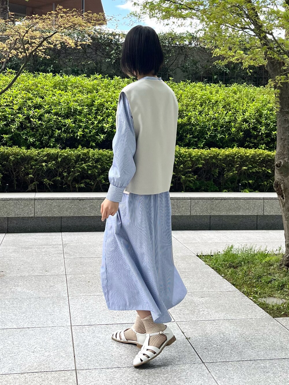 ホワイト系のサンダル、ブルー系のワンピース、ベージュ系のセットアップを着用したレディースの夏コーディネートの3枚目の写真