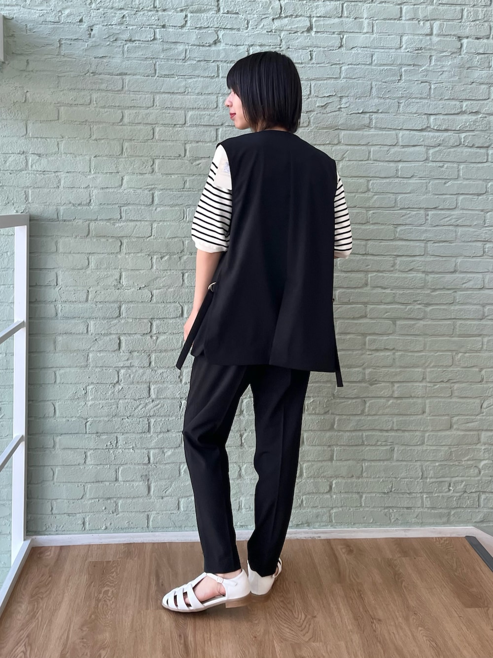 ホワイト系のサンダル、ブラック系のその他パンツ、ベージュ系のニット/セーターを着用したレディースの春コーディネートの2枚目の写真