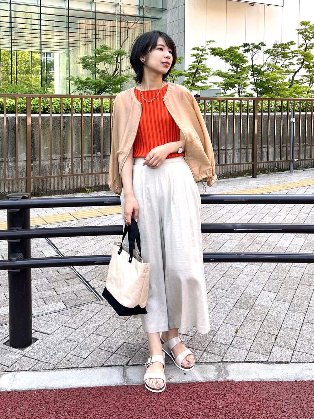 ホワイト系のサンダル、レッド系のニット/セーター、イエロー系のブルゾンを着用したレディースの夏コーディネートの3枚目の写真