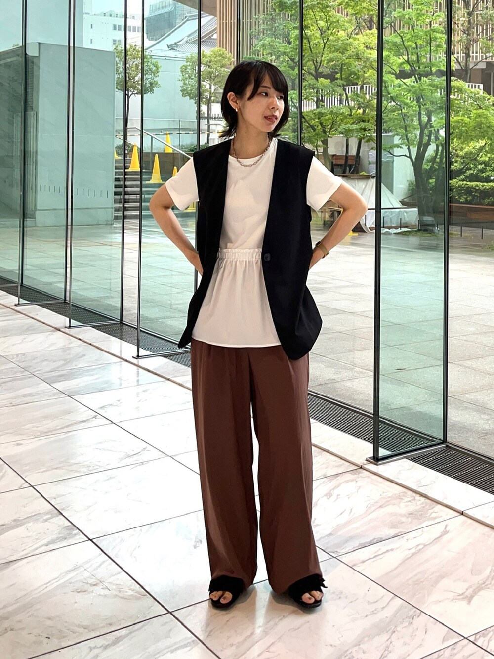 ブラウン系のその他パンツ、ブラック系のサンダル、ホワイト系のTシャツ/カットソーを着用したレディースの夏コーディネートの2枚目の写真