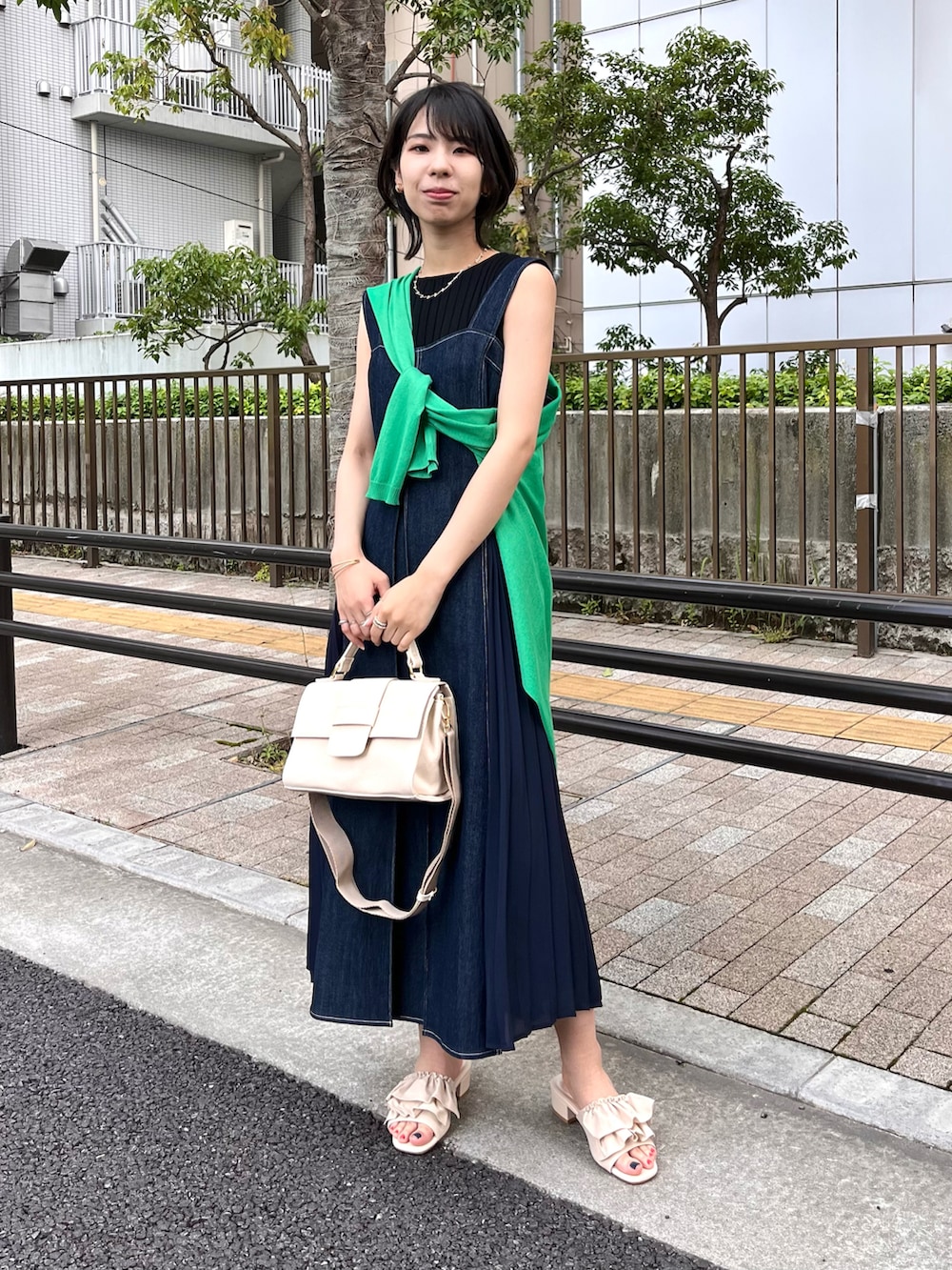 ホワイト系のショルダーバッグ、ホワイト系のサンダル、グリーン系のカーディガン/ボレロを着用したレディースの夏コーディネートの4枚目の写真