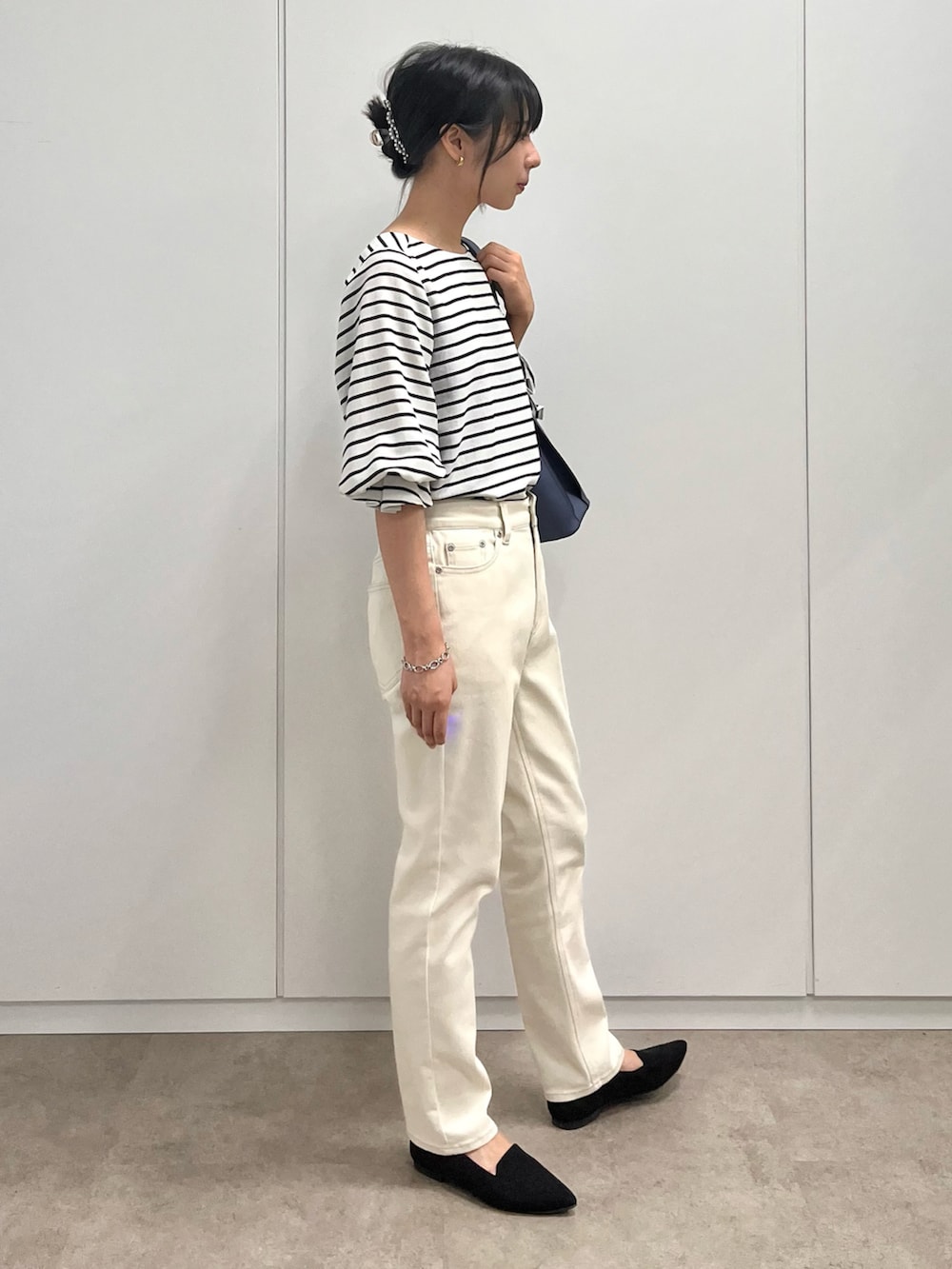 ブラック系のシャツ/ブラウス、ブルー系のショルダーバッグ、ホワイト系のデニムパンツを着用したレディースの秋コーディネートの4枚目の写真