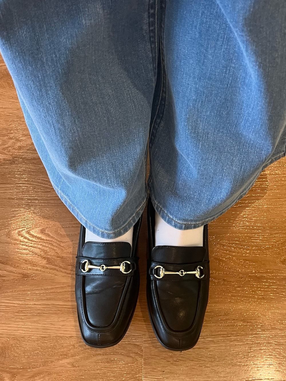 グレー系のテーラードジャケット、グリーン系のニット/セーター、ブルー系のデニムパンツを着用したレディースの秋コーディネートの5枚目の写真