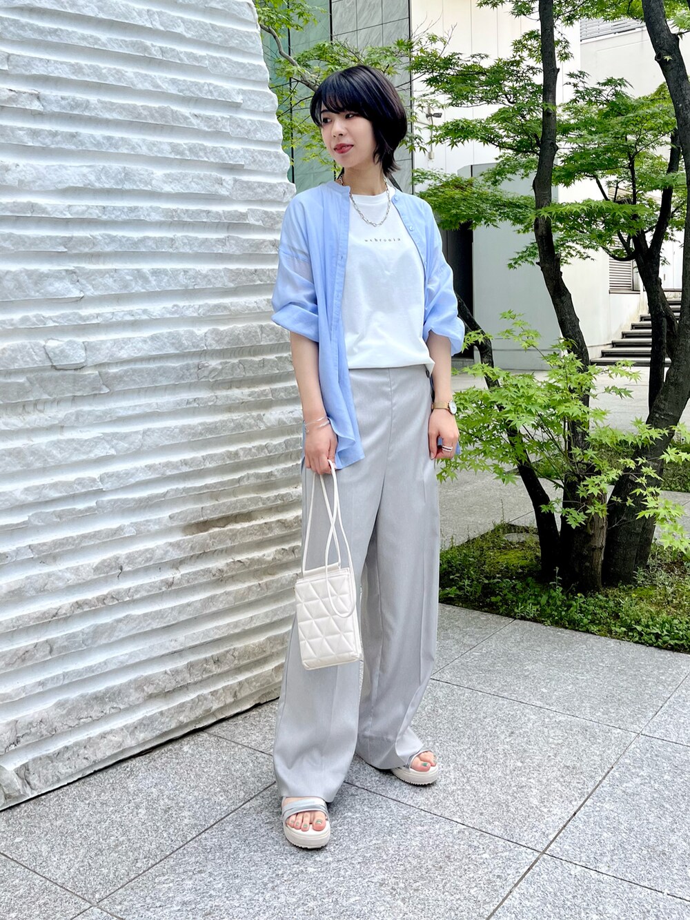 シルバー系のサンダル、グレー系のその他パンツ、ホワイト系のショルダーバッグを着用したレディースの春コーディネートの3枚目の写真