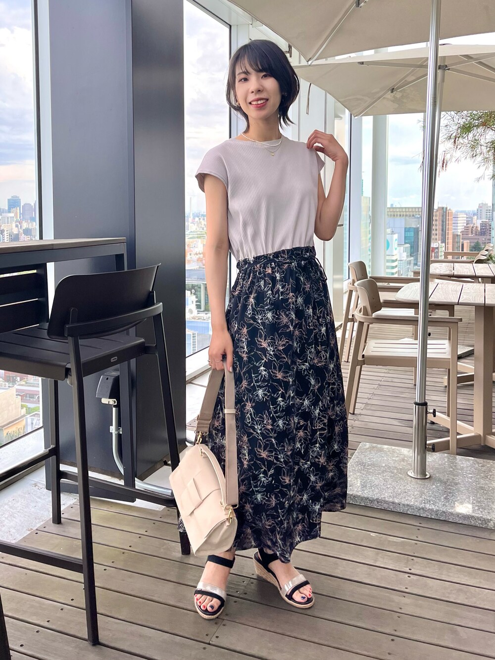 ブラック系のサンダル、ブラック系のワンピース、ホワイト系のショルダーバッグを着用したレディースの夏コーディネートの4枚目の写真