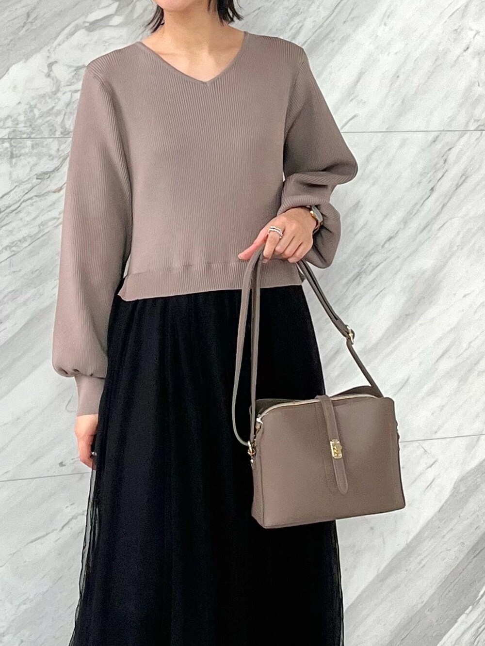 グレー系のショルダーバッグ、ブラック系のブーツ、ブラウン系のワンピースを着用したレディースの秋コーディネートの4枚目の写真