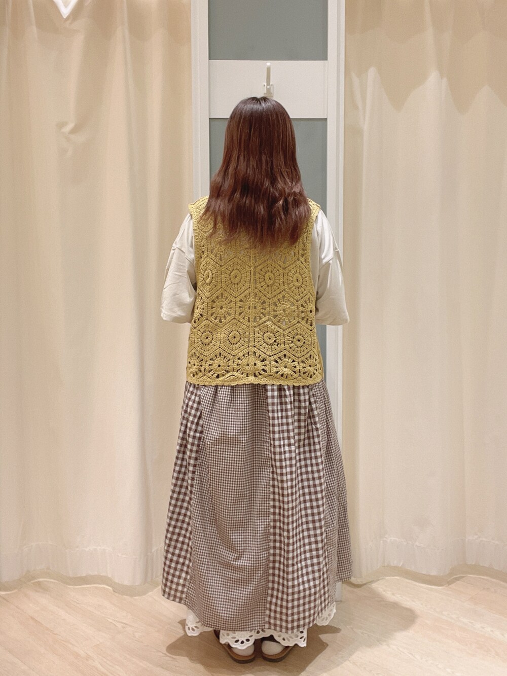 ベージュ系のトートバッグ、ブラウン系のサンダル、ホワイト系のスカートを着用したレディースの夏コーディネートの4枚目の写真