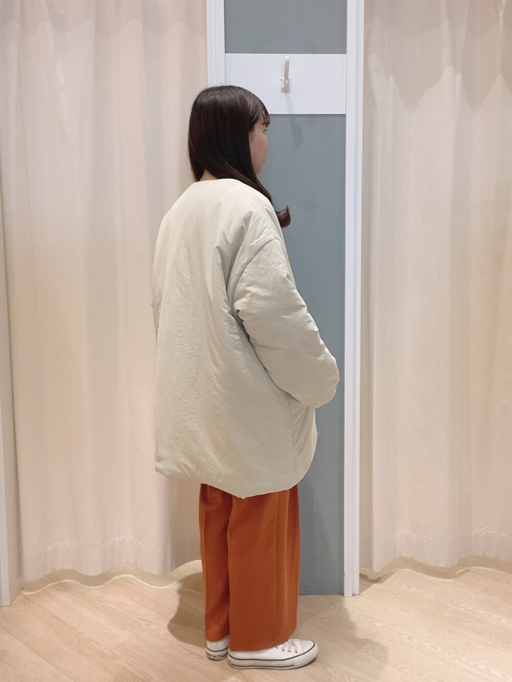 オレンジ系のその他パンツ、ホワイト系のスニーカー、ホワイト系のノーカラージャケットを着用したレディースの冬コーディネートの2枚目の写真