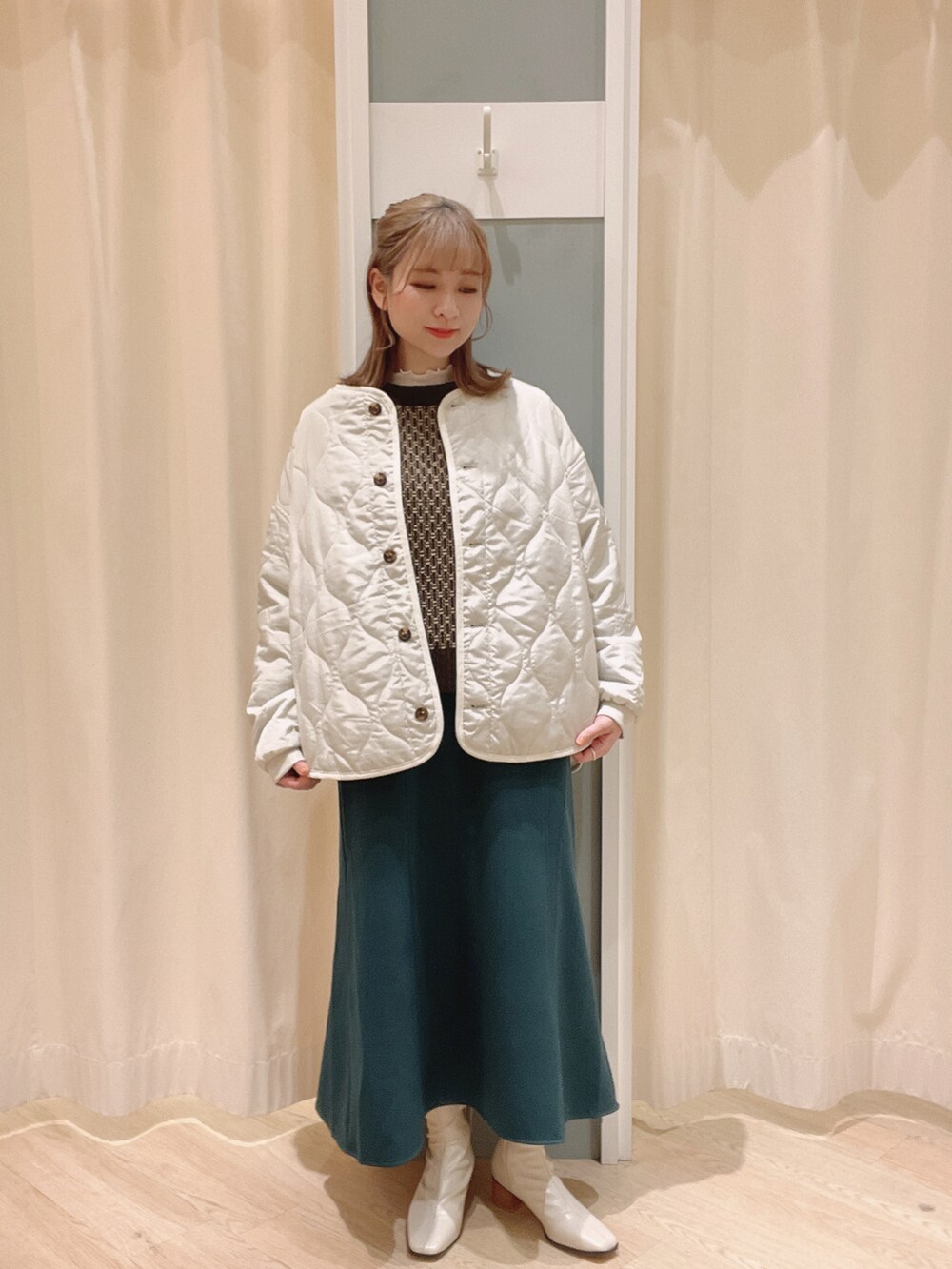 ホワイト系のブーツ、ホワイト系のTシャツ/カットソー、ホワイト系のノーカラージャケットを着用したレディースの冬コーディネートの3枚目の写真