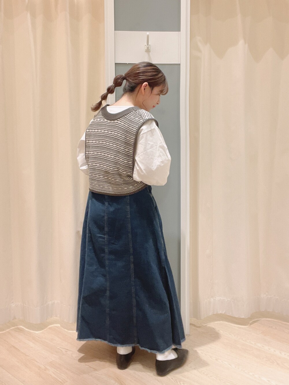 ブラック系のその他シューズ、ブルー系のデニムスカート、ベージュ系のトートバッグを着用したレディースの春コーディネートの3枚目の写真