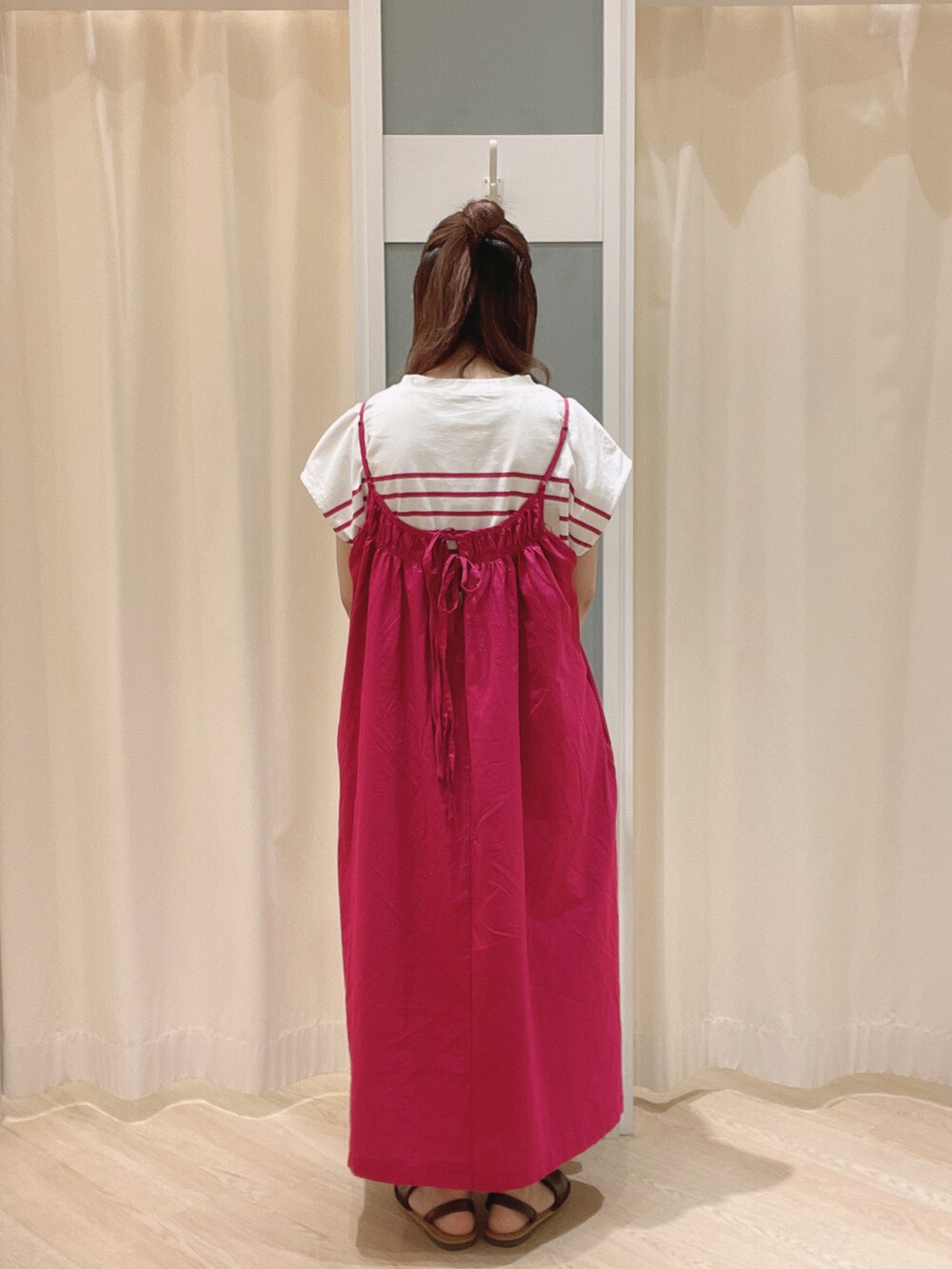 ホワイト系のトートバッグ、ブラウン系のサンダル、ピンク系のワンピースを着用したレディースの夏コーディネートの3枚目の写真