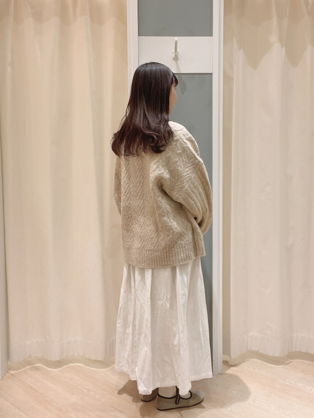 ベージュ系のドレスシューズ、ホワイト系のスカート、ベージュ系のニット/セーターを着用したレディースの冬コーディネートの2枚目の写真