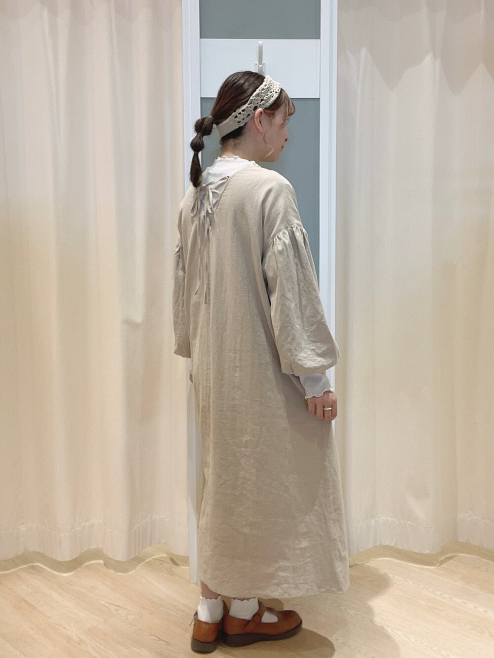 ブラウン系のシューズ、ベージュ系のワンピース、ホワイト系のTシャツ/カットソーを着用したレディースの秋コーディネートの2枚目の写真