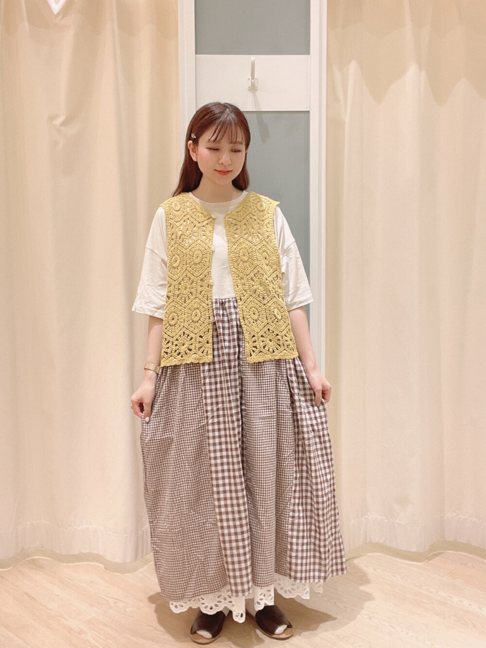 ベージュ系のトートバッグ、ブラウン系のサンダル、ホワイト系のスカートを着用したレディースの夏コーディネートの2枚目の写真