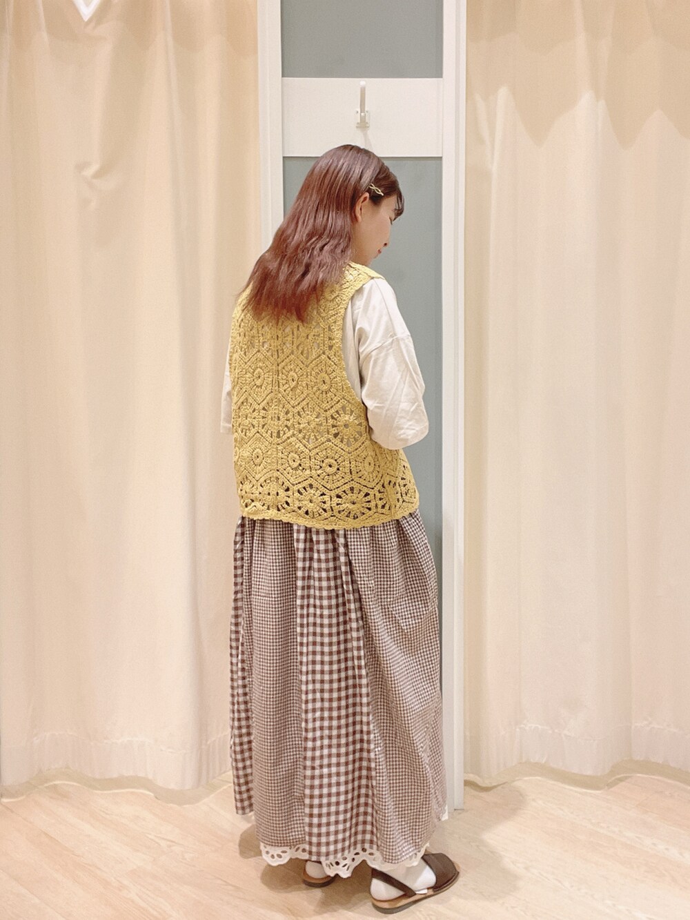 ベージュ系のトートバッグ、ブラウン系のサンダル、ホワイト系のスカートを着用したレディースの夏コーディネートの3枚目の写真