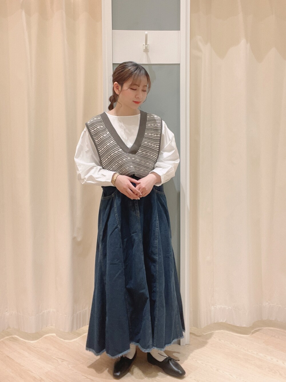 ブラック系のその他シューズ、ブルー系のデニムスカート、ベージュ系のトートバッグを着用したレディースの春コーディネートの2枚目の写真