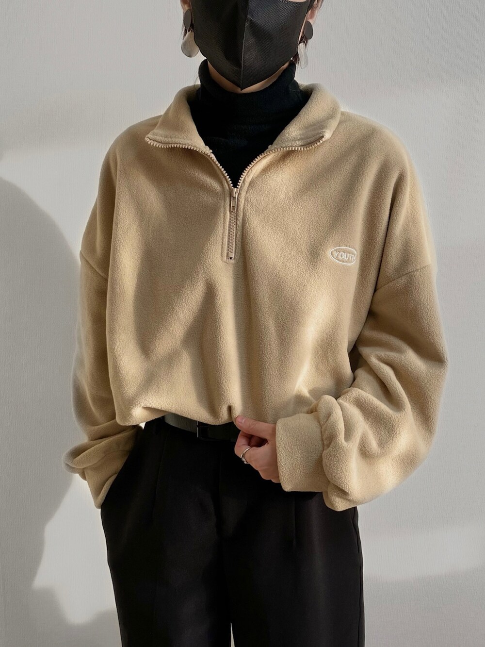 ベージュ系のトップス、ブラック系のスラックス、ブラック系のシューズを着用したレディースの秋コーディネートの3枚目の写真