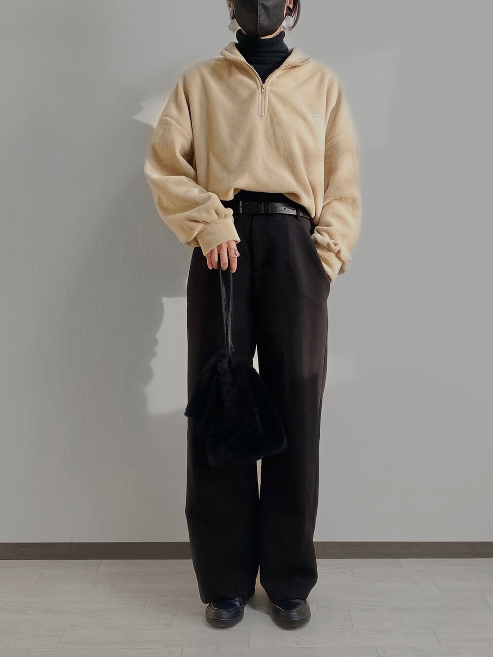 ベージュ系のトップス、ブラック系のスラックス、ブラック系のシューズを着用したレディースの秋コーディネートの2枚目の写真