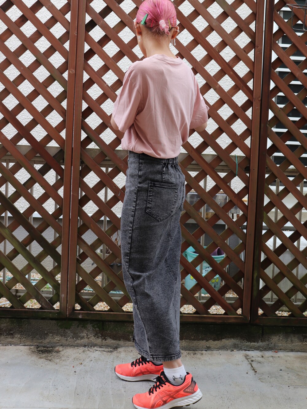 ブラック系のデニムスカート、オレンジ系のスニーカーを着用したレディースの夏コーディネートの2枚目の写真