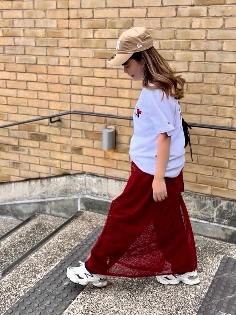 ホワイト系のTシャツ/カットソー、ブラック系のボディバッグ/ウエストポーチ、ブルー系のデニムパンツを着用したレディースの夏コーディネートの3枚目の写真