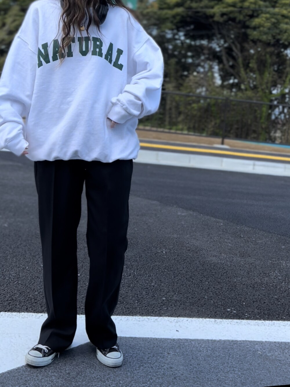 ブラック系のスラックス、ホワイト系のスウェット、ブラック系のその他を着用したレディースの春コーディネートの2枚目の写真