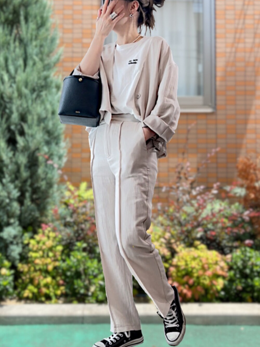 ブラック系のハンドバッグ、グレー系のセットアップ、ホワイト系のTシャツ/カットソーを着用したレディースの夏コーディネートの2枚目の写真