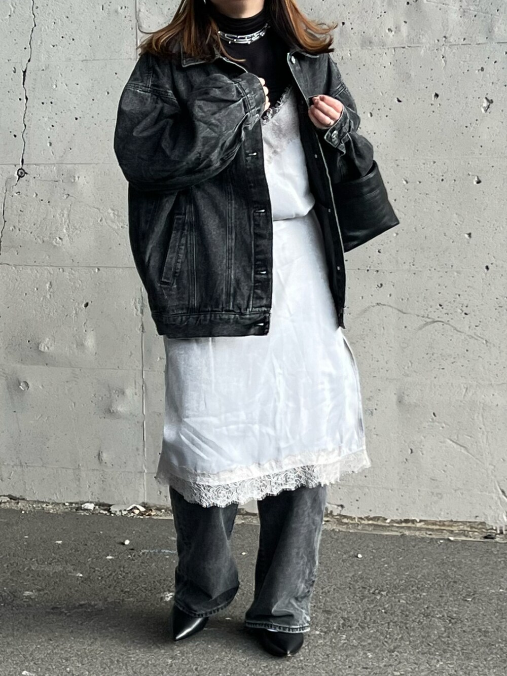 ブラック系のデニムジャケット、グレー系のワンピース、ブラック系のパンプスを着用したレディースの冬コーディネートの3枚目の写真