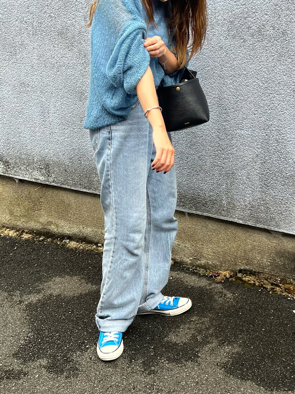 ブルー系のニット/セーター、ホワイト系のタンクトップ、ブルー系のデニムパンツを着用したレディースの秋コーディネートの3枚目の写真