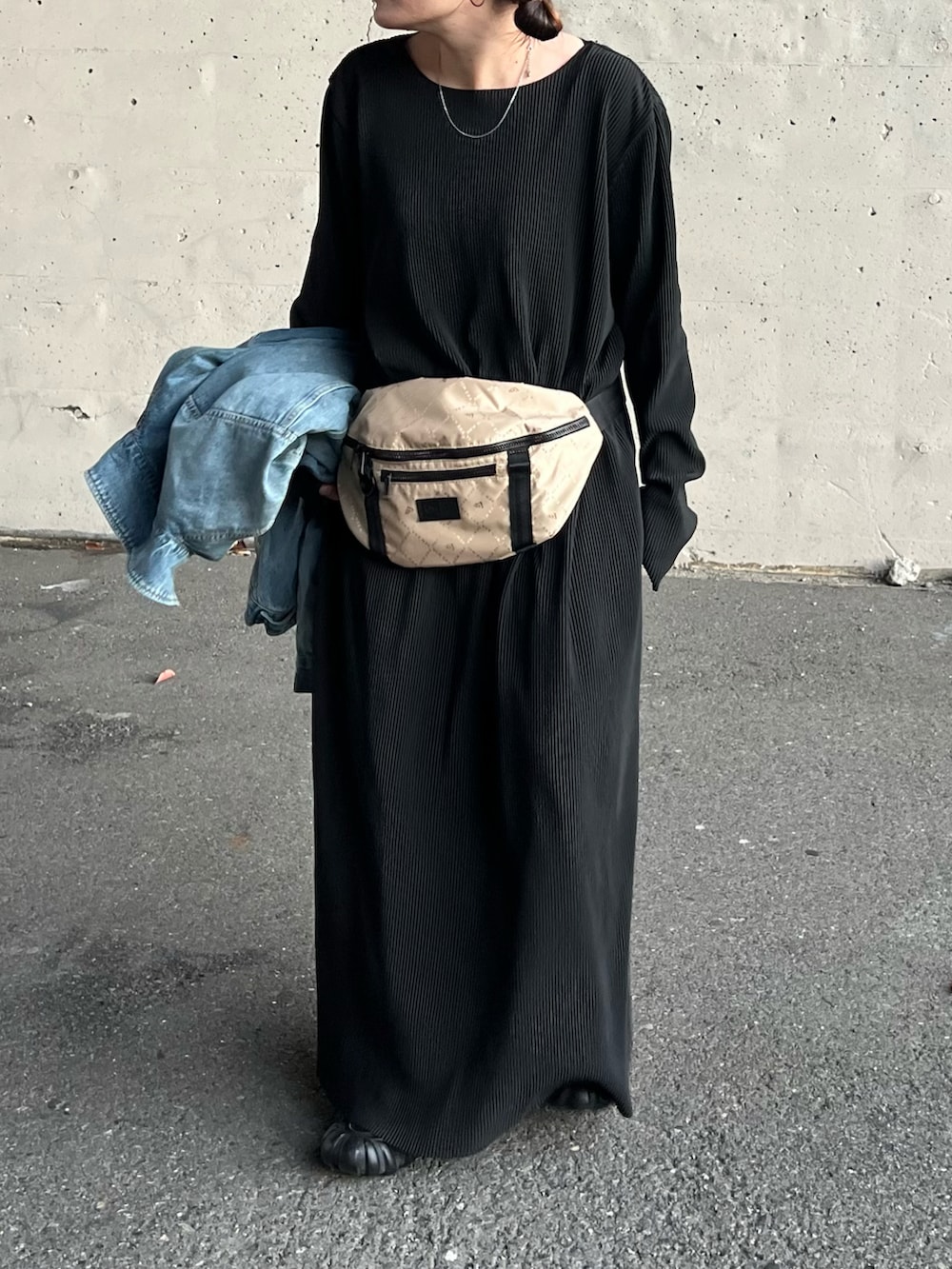 ブラック系のワンピース、ブルー系のデニムジャケット、ブラック系のスニーカーを着用したレディースの秋コーディネートの2枚目の写真