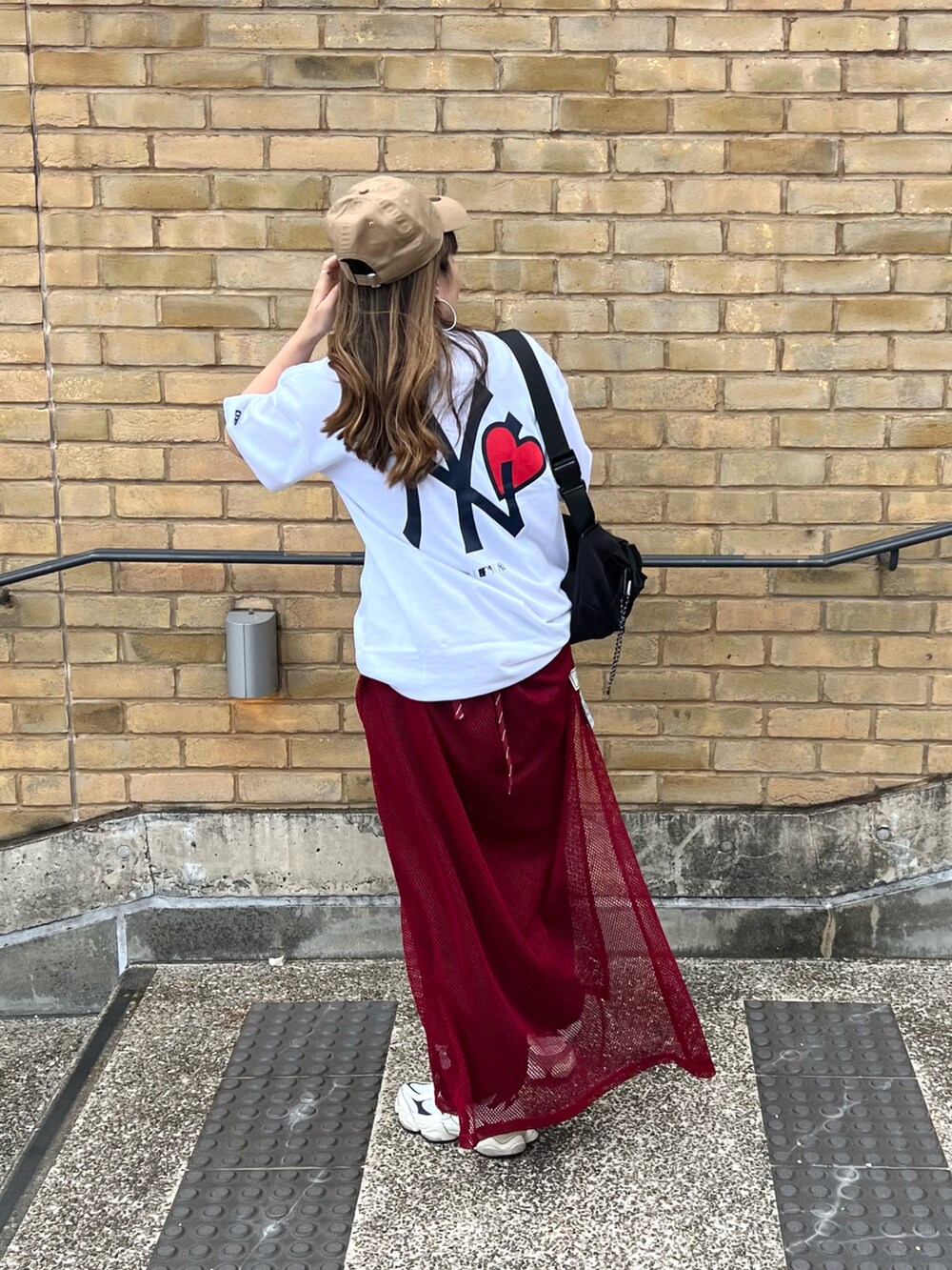 ホワイト系のTシャツ/カットソー、ブラック系のボディバッグ/ウエストポーチ、ブルー系のデニムパンツを着用したレディースの夏コーディネートの2枚目の写真