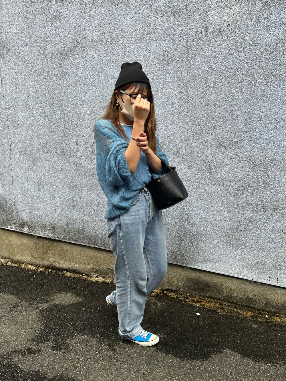 ブルー系のニット/セーター、ホワイト系のタンクトップ、ブルー系のデニムパンツを着用したレディースの秋コーディネートの2枚目の写真